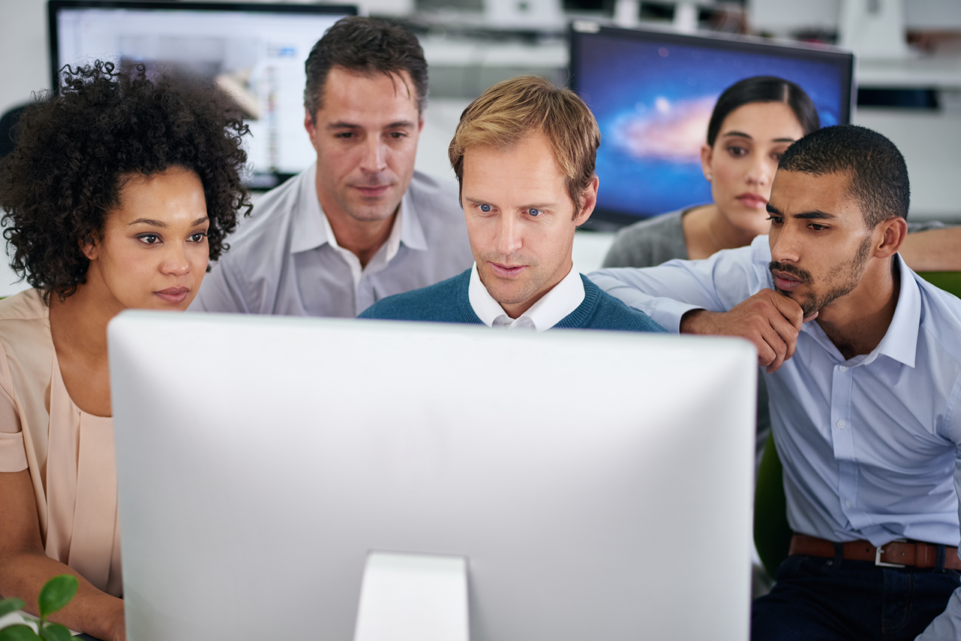 A group of people working in front of a computer